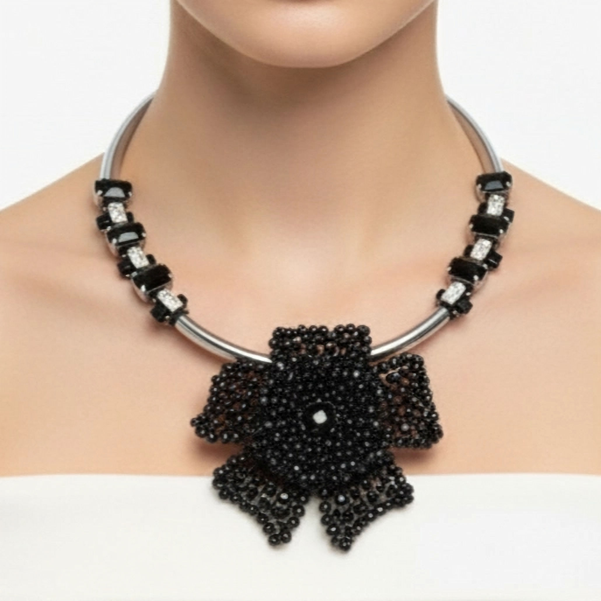 Rigid silver choker necklace with large black beaded flower and faceted crystals.