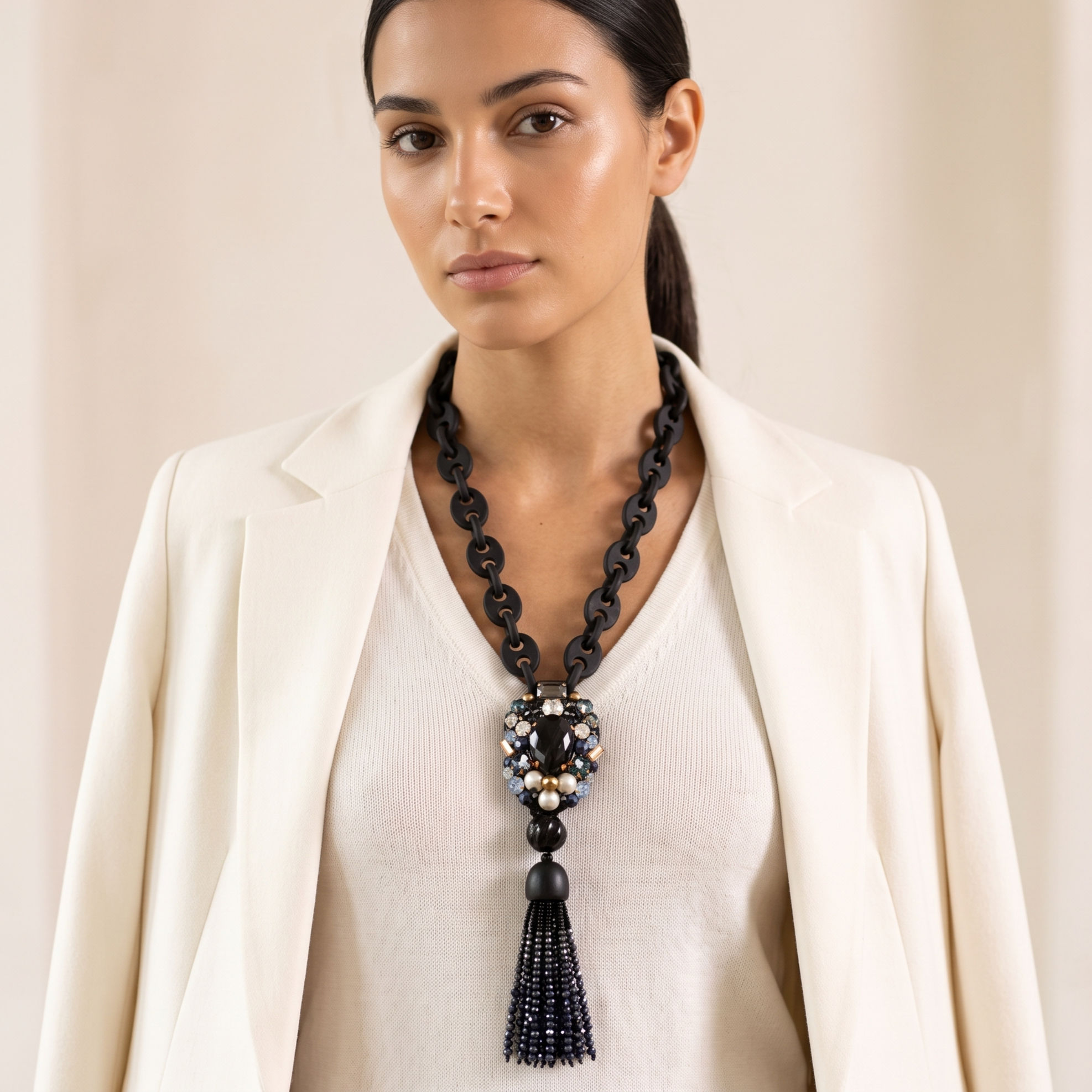 Handcrafted long statement necklace featuring a black-link chain, a jeweled pendant, and a crystal tassel.