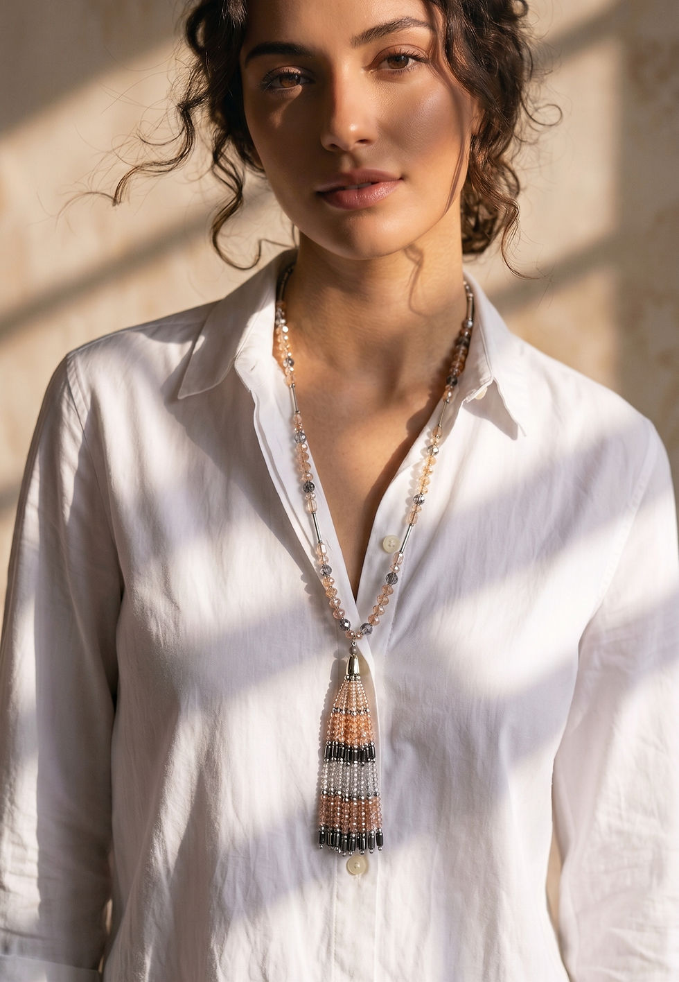 Long, artisan-designed necklace featuring a jeweled tassel made of champagne-colored crystals and silver.