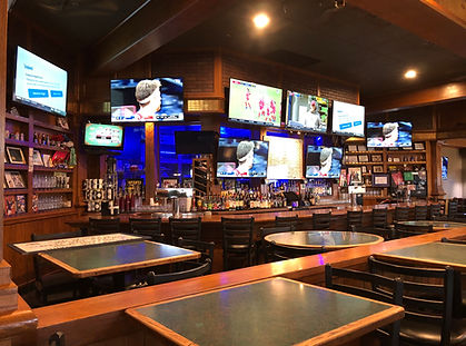Bar with televisions and high top bar seating.