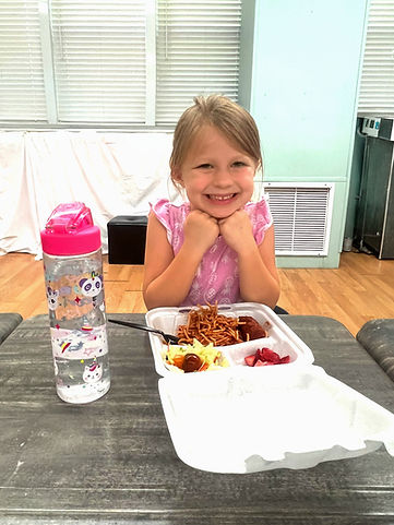 Child smiling with free summer lunch provided by SOS Foundation in Monroe County, Florida Keys