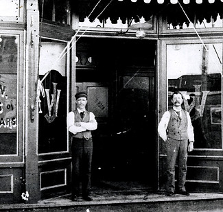 a black & white photo from around 1900 of two men standing outside Jack's Saloon in Key West, where Key West Legal Rum distillery would eventually be