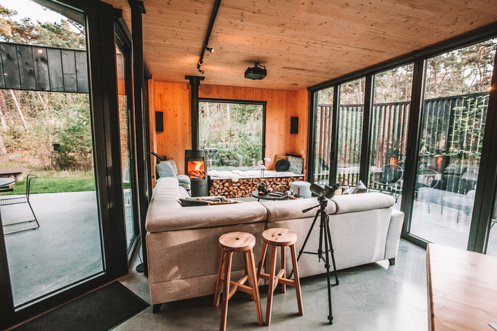Woonkamer van Bosvilla Zwarte Zwaan met grote ramen naar het bos