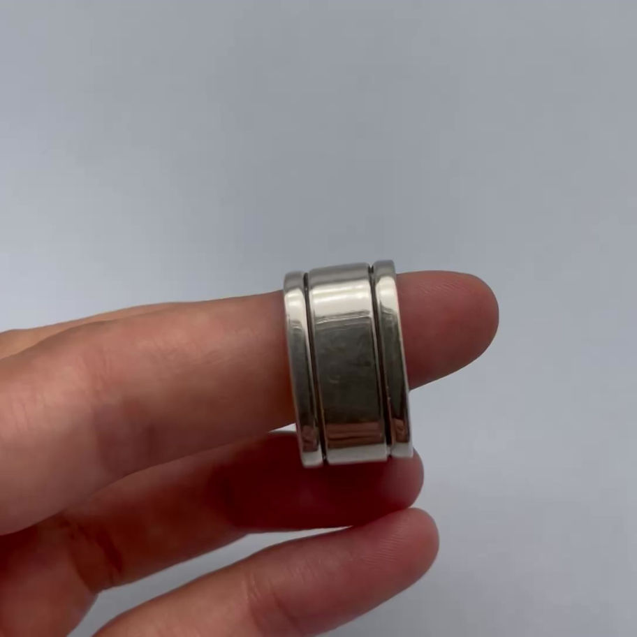 Square Men’s Ring held between fingers, showing the wide band and structured silver profile.