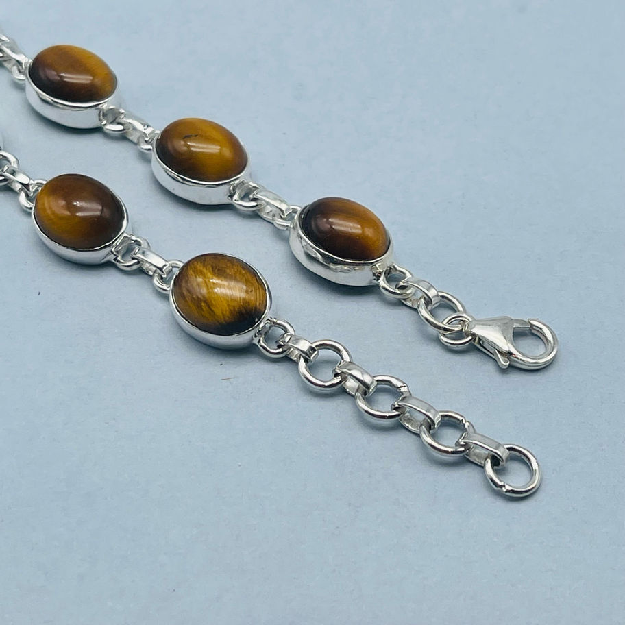 Close-up of a Tiger’s Eye silver bracelet showing oval stones and chain detail.
