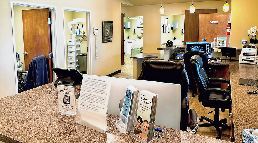 Reception desk with printed materials and chairs, in a medical office setting.