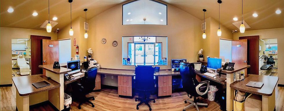 Reception area of a dental office with desks, chairs, and computers