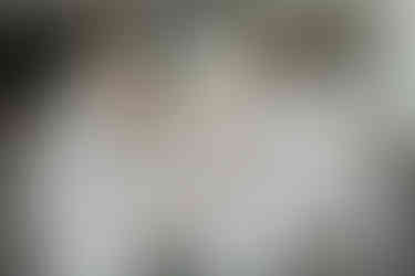 en gruppbild på tandläkare tagen framför en neutral grå byggnad i bakgrunden under en porträttfotografering för en tandläkarpraktik