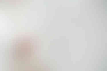 en digital designer sitter på golvet med sin dator i en stor ljus lokal och  ler mot kameran under en branding fotografering 