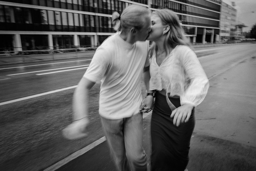 en suddig bild av ett kärlekspar som springer samtidigt som de håller hand och kyssas