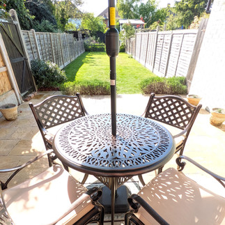 Metal dining set on patio of enclosed garden atr Sea View Cottage, Frinton-on-Sea