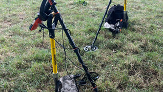 two metal detectors resting in a field
