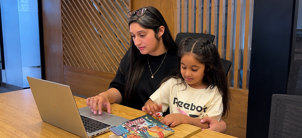 A woman sitting beside her child at her work desk.