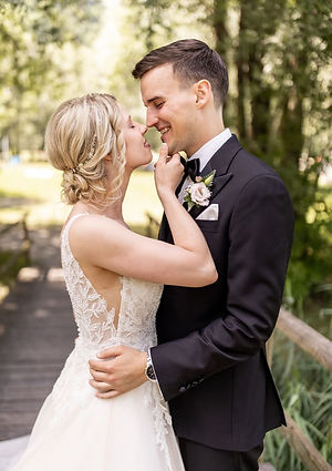 Ein lachendes Brautpaar blickt sich beim Paarshooting in der Natur tief in die Augen