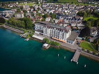 Drohnenbild vom Waldstätterhof Brunnen mit See und Bergen, aufgenommen von Hochzeitsfotograf Mischa Baettig. Hochzeitsbilder in der Schweiz.