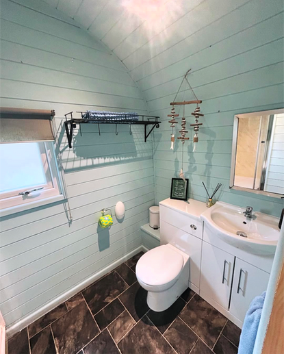 A light blue Bathroom in the Ayr glamping pod at Emlyn's Coppice.