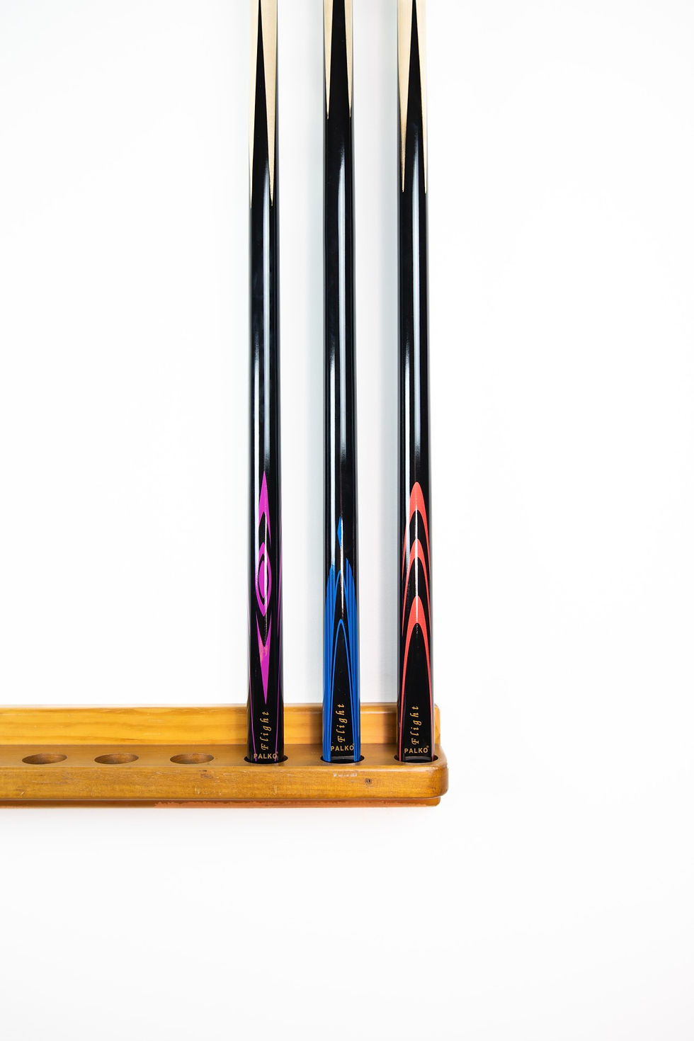 Three billiard cues in a wooden rack