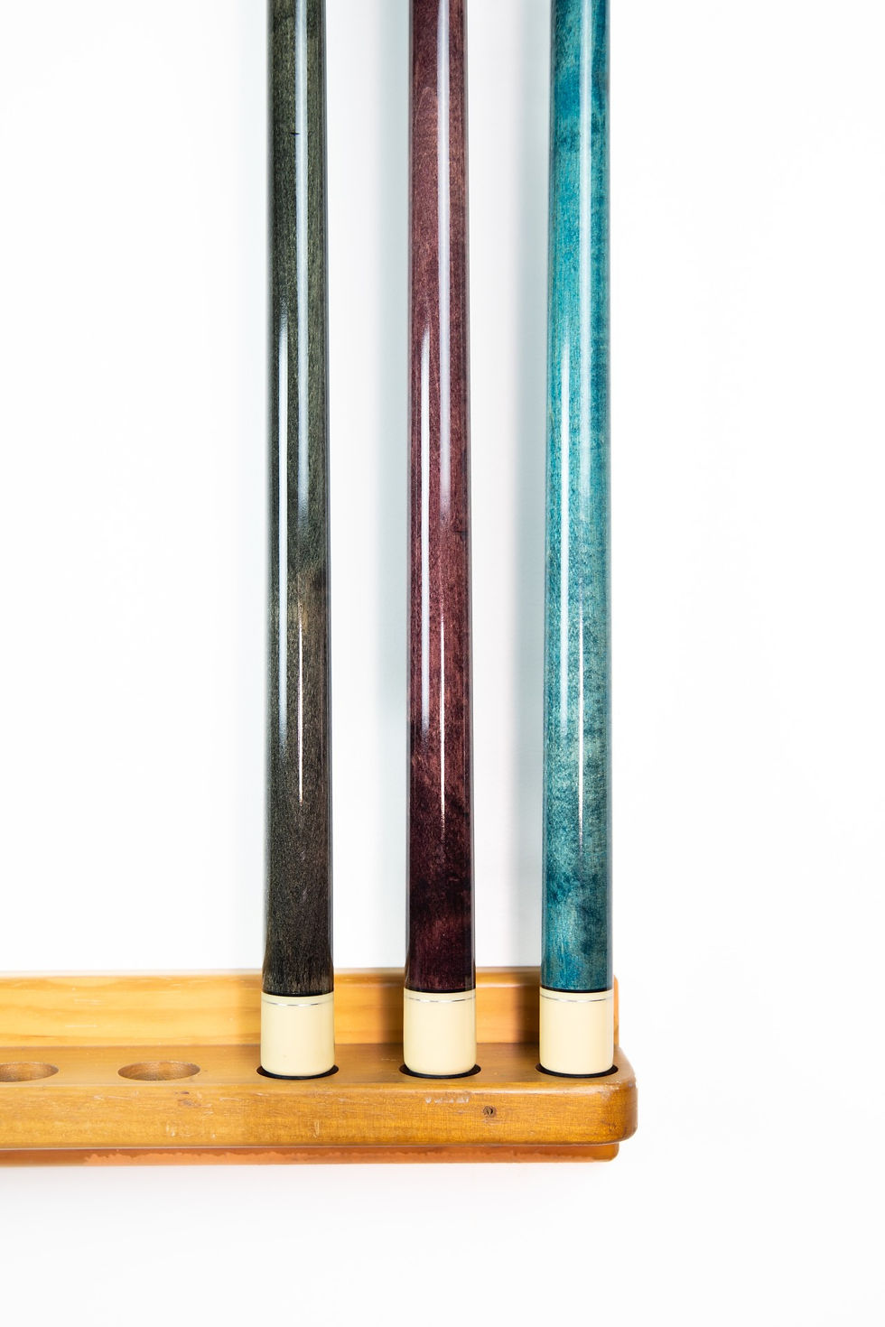 Three billiard cues: purple, grey, teal