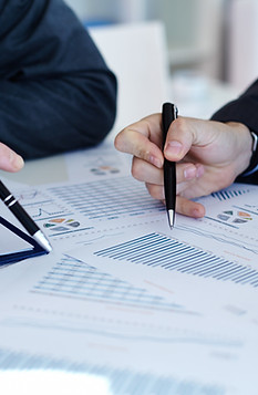 Hands of two people writing on a sheet of paper Analyzing Data