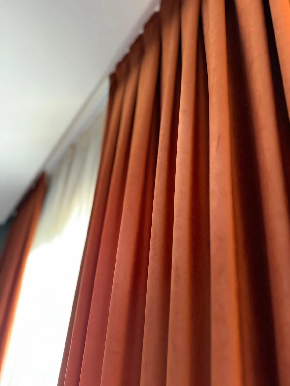 Rideaux sur-mesure posés dans une baie vitrée pour un intérieur moderne