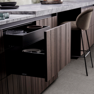 Gros plan façade bois strié vertical foncé LEICHT avec tiroir intégré et plan de travail marbre — Ambiance Cuisines Nice