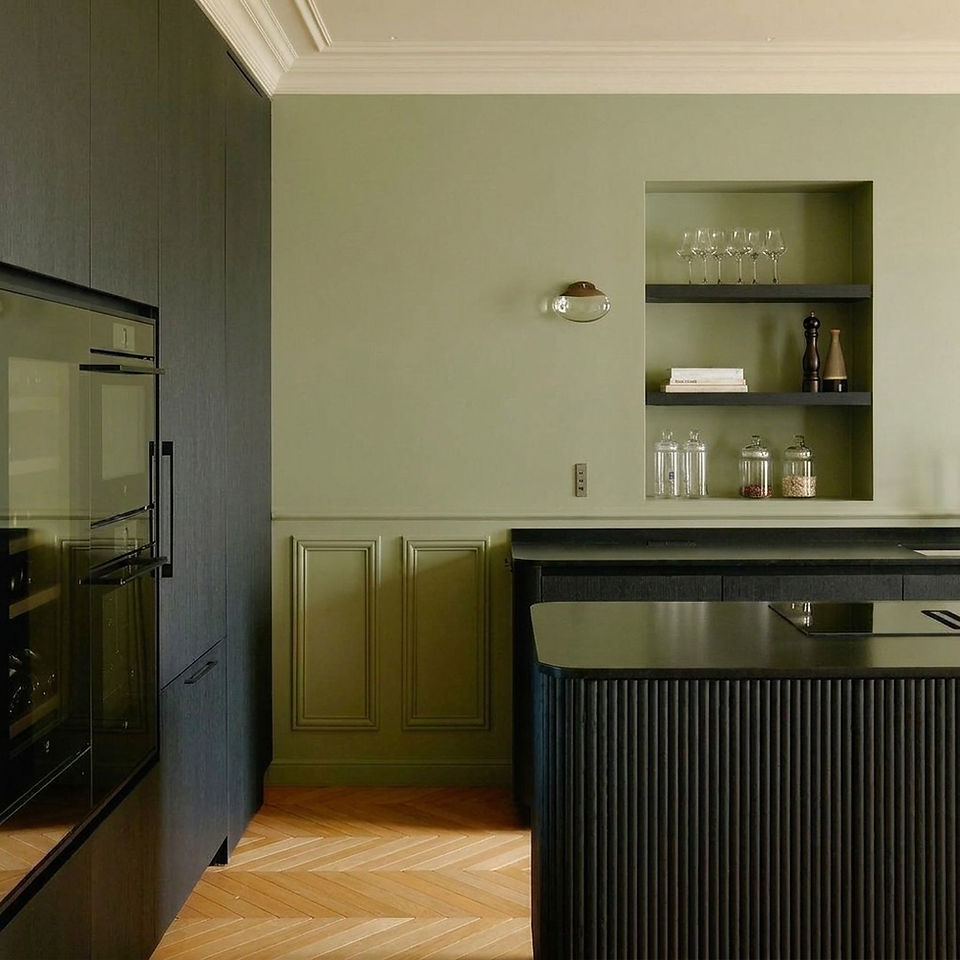 Cuisine avec îlot à panneaux cannelés et mur à moulures vert olive, sans carrelage à Nice