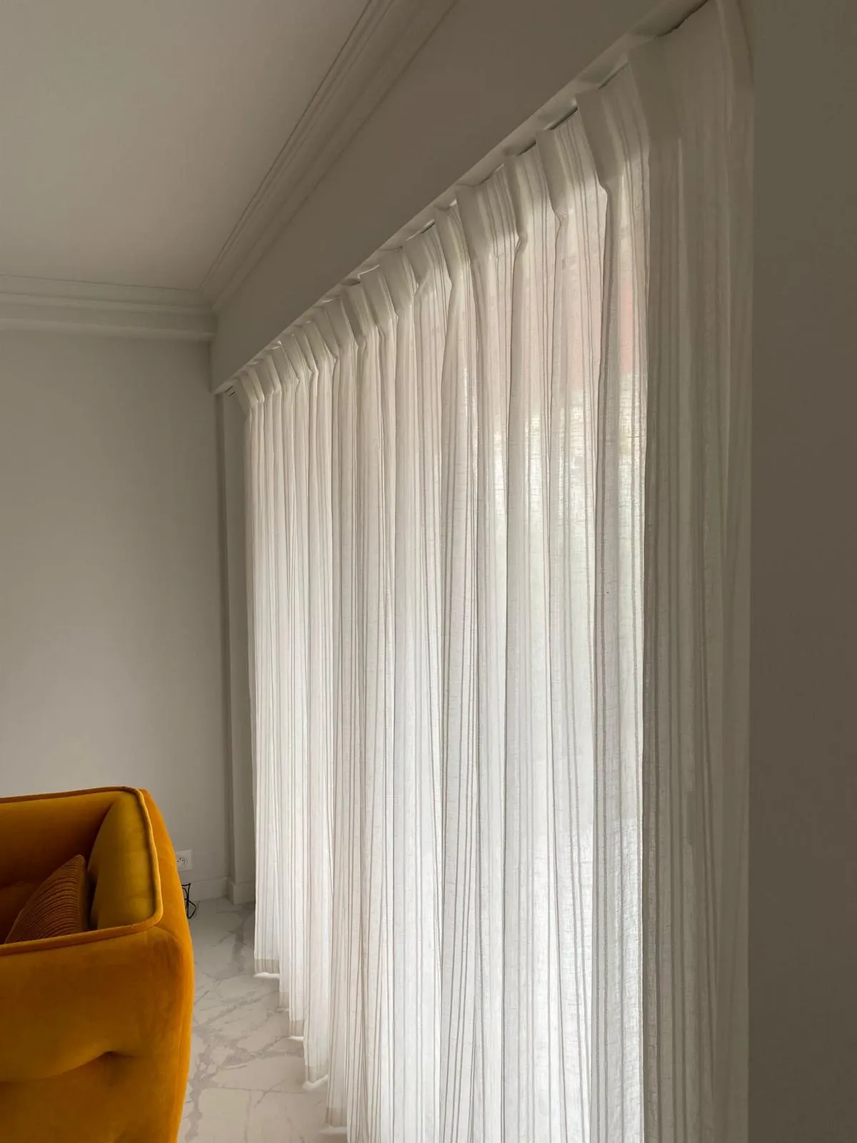 Salon lumineux habillé de voilages translucides contemporains