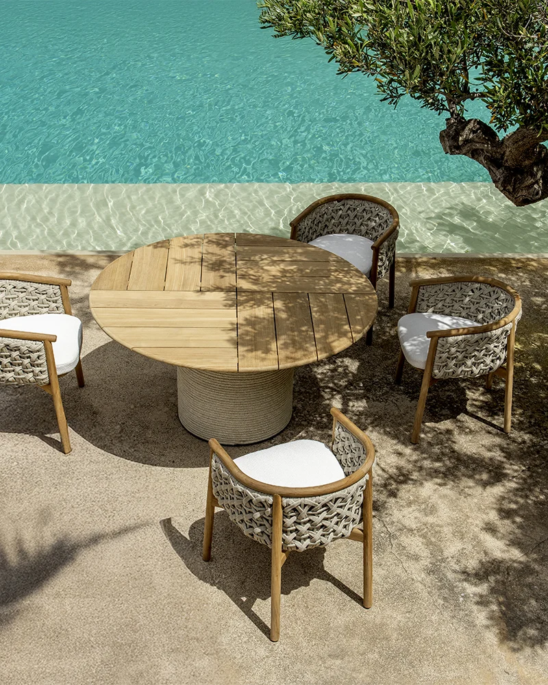 Table d’appoint extérieure Ethimo avec fauteuil design près de piscine