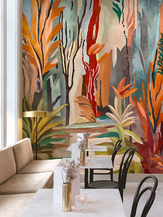 Mural Masureel panoramique jungle aux feuillages orangés, rouges et verts sur fond bleu-gris, décor intérieur contemporain – Atelier Marceau Nice