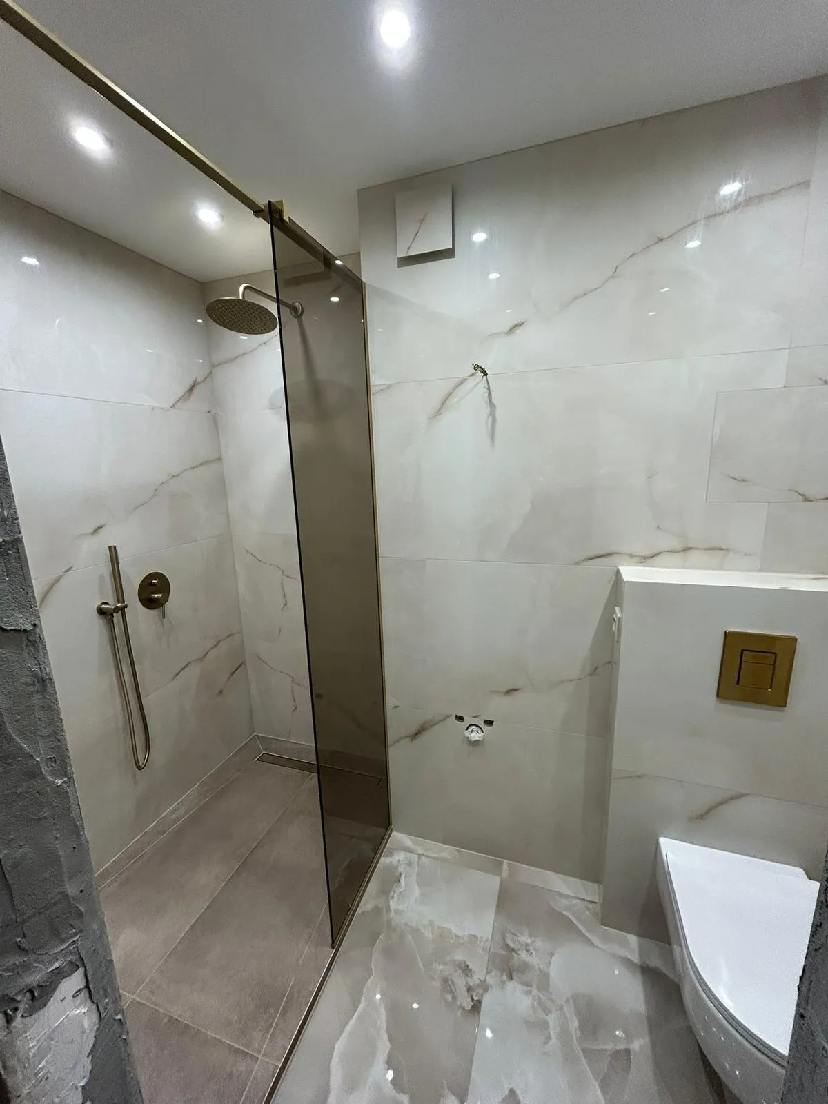 Rénovation salle de bain à Bastia avec douche à l’italienne moderne et carrelage effet marbre – SFT Toitures.