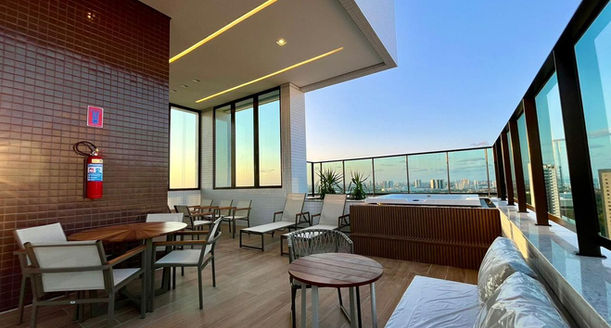Espaço Wellness e relax no rooftop decorado com mobiliário premium e iluminação intimista.