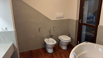 Porzione di parete realizzata in resina materica per ricoprire piastrelle esistenti