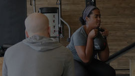 Lakeland gym member getting feedback from a coach on her form during a group class session.