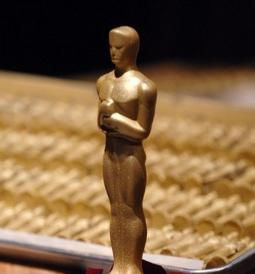 Golden Oscar statuette on a chocolate cake with rose petals