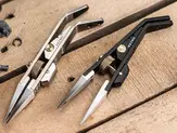 MetMo Precision Grip tweezers in silver and black, showing the needle-point jaws and the knurled brass pressure adjuster.