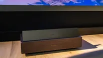 XGIMI AURA 3 Max UST projector showing its low-profile laser TV design beneath a large projected image.