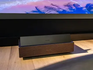 XGIMI AURA 3 Max UST projector showing its low-profile laser TV design beneath a large projected image.