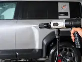 ROKEKO Washer on Kickstarter cleaning the side of a vehicle with a focused cordless pressure spray.