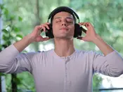 Man wearing Sychedelic tDCS headphones with eyes closed during a focus or relaxation session