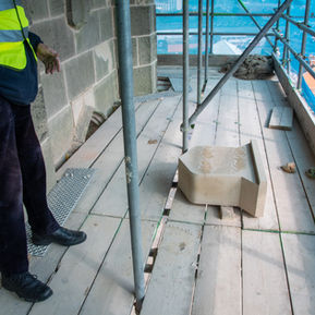 Worker in safety vest on construction scaffolding
