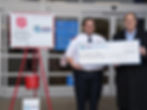 Savannah River Mission Completion President and Program Manager Dr. Thomas Burns, Jr. (right) presents a $5,000 check to Salvation Army Captain Michael Good and rings the bell as part of the Salvation Army’s annual Red Kettle Campaign.