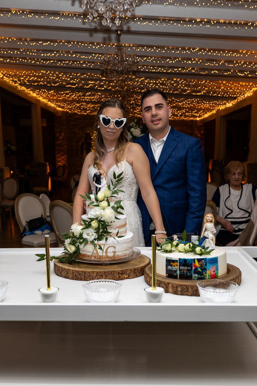 Boldog pár esküvői tortákkal, mókás napszemüveges menyasszony, boldog pillanatok.