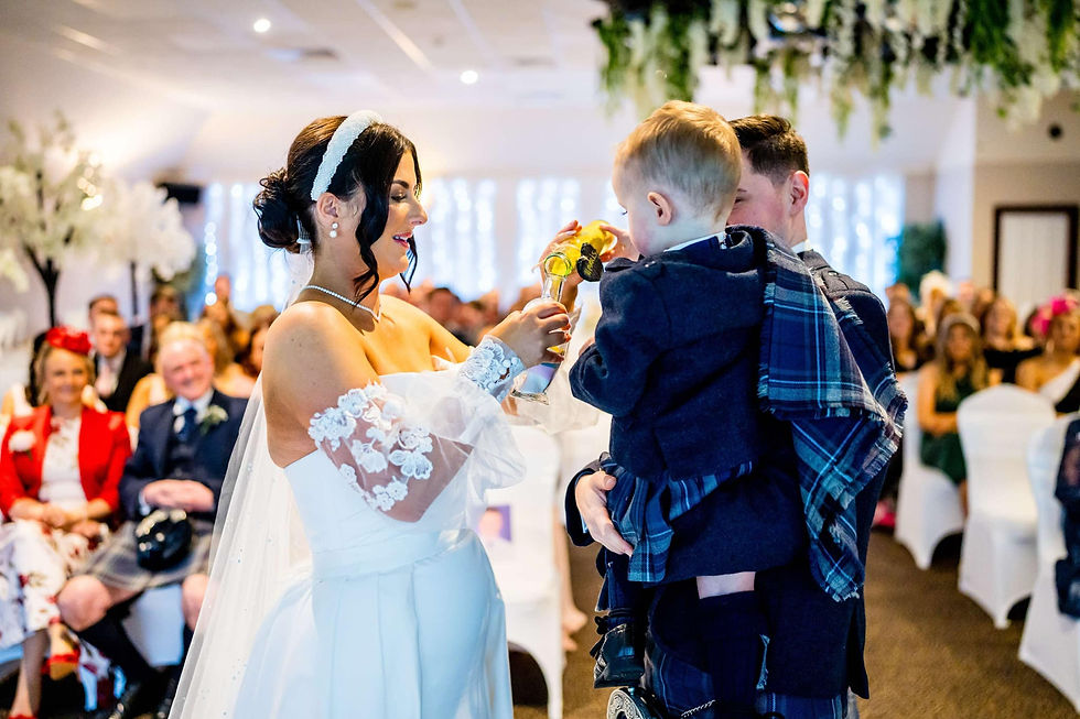 Bride and groom performing a sand unity ceremony with their son