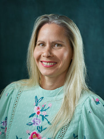 Smiling woman, teal floral blouse