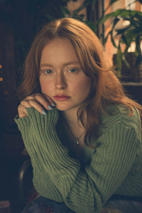 Portrait of a woman smiling softly against a neutral background