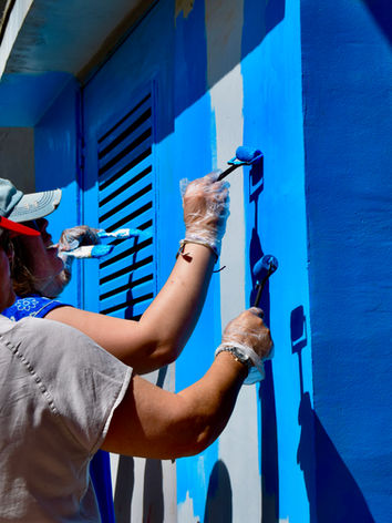 Duas mulheres pintam a parede azul com tinta, trabalho voluntário, Artepublica.pt