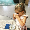 Here a small child is drinking from a small teacup, perhaps for the annual Little Rascals Mother's Day tea?