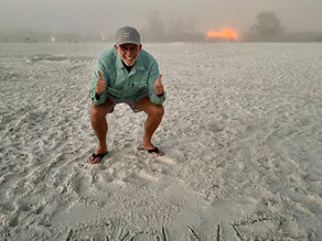 Travis Thomas on the beach with his word of the year for 2025: evolve