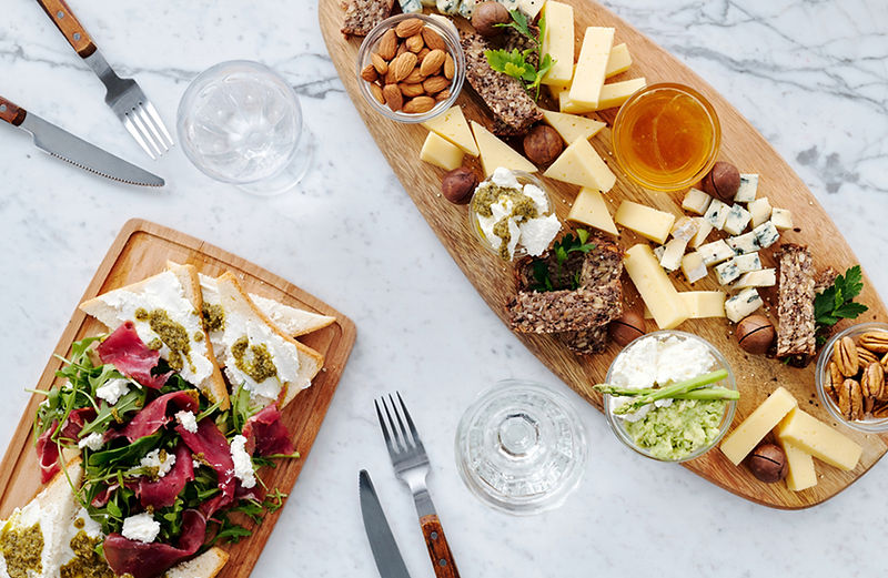 A charcuterie board with nuts and cheeses