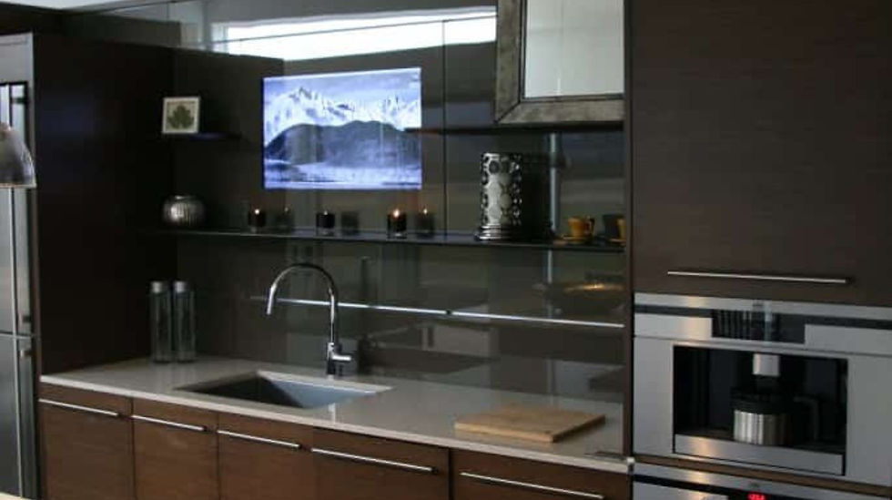 Humble Creek Construction luxury modern minimalist kitchen featuring dark wood integrated appliances and glass shelves
